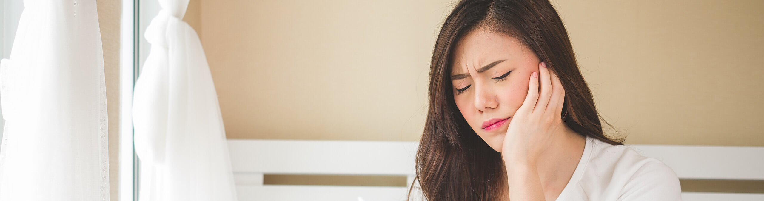 woman holding her jaw in pain